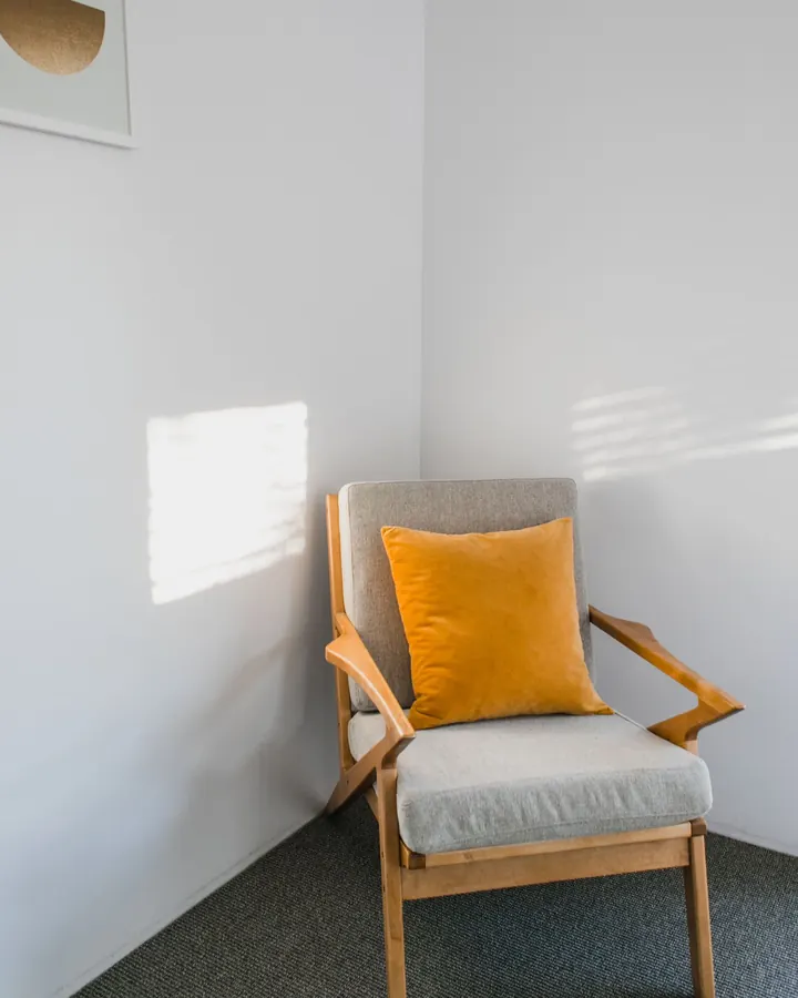 Wooden-arm armchair with a grey seat and a mustard cushion