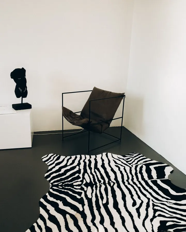 Black sling chair on a black and white patterned rug