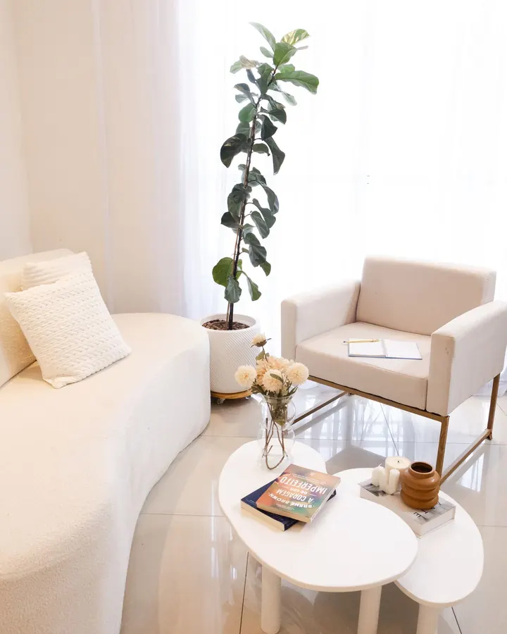 Low white sofa with a slim armchair beside it