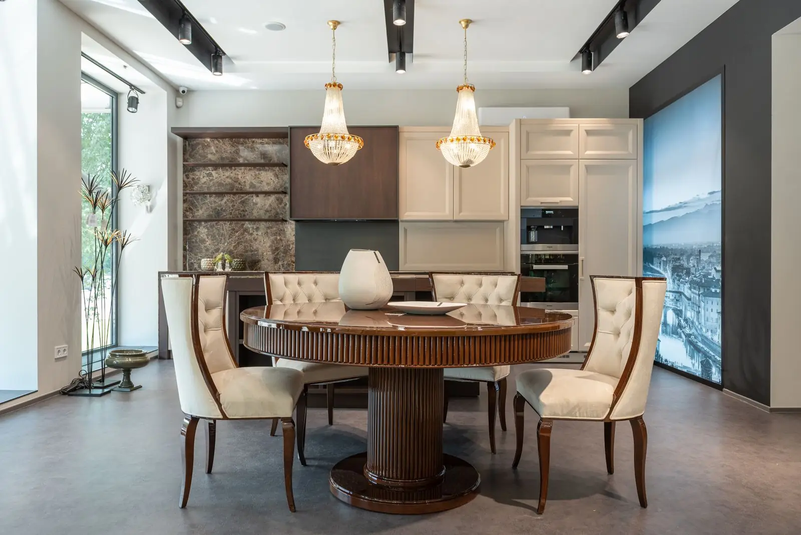 Round dining table with cream upholstered chairs under pendant lights